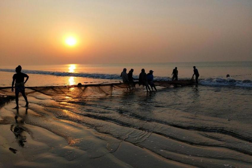 Fishermen pulling in nets at sunrise on Digha Beach, capturing a serene coastal scene. Photo: Pexel