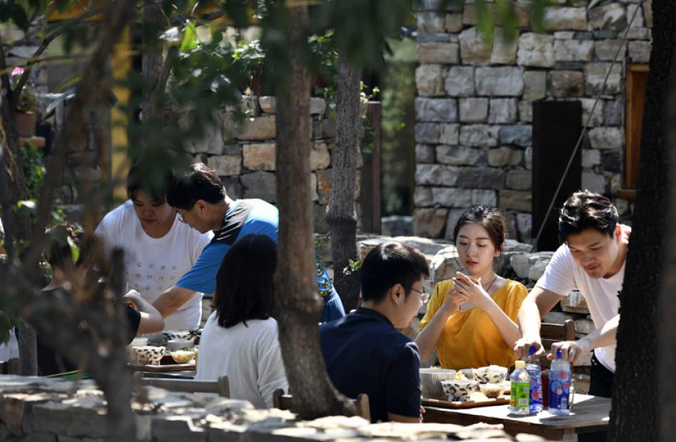 Images of the Day:Tourists rest in a yard of a homestay in Xijingyu Village
