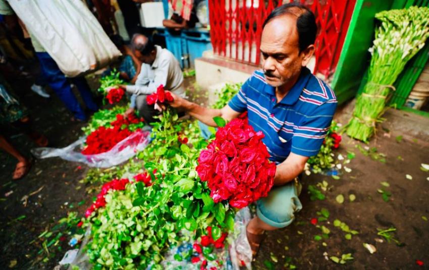 Hands at work, a flower seller arranges a bouquet amid the morning rush. Photo: Avishek Mitra